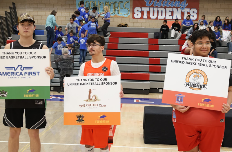 Unified sports players holding sponsor signs