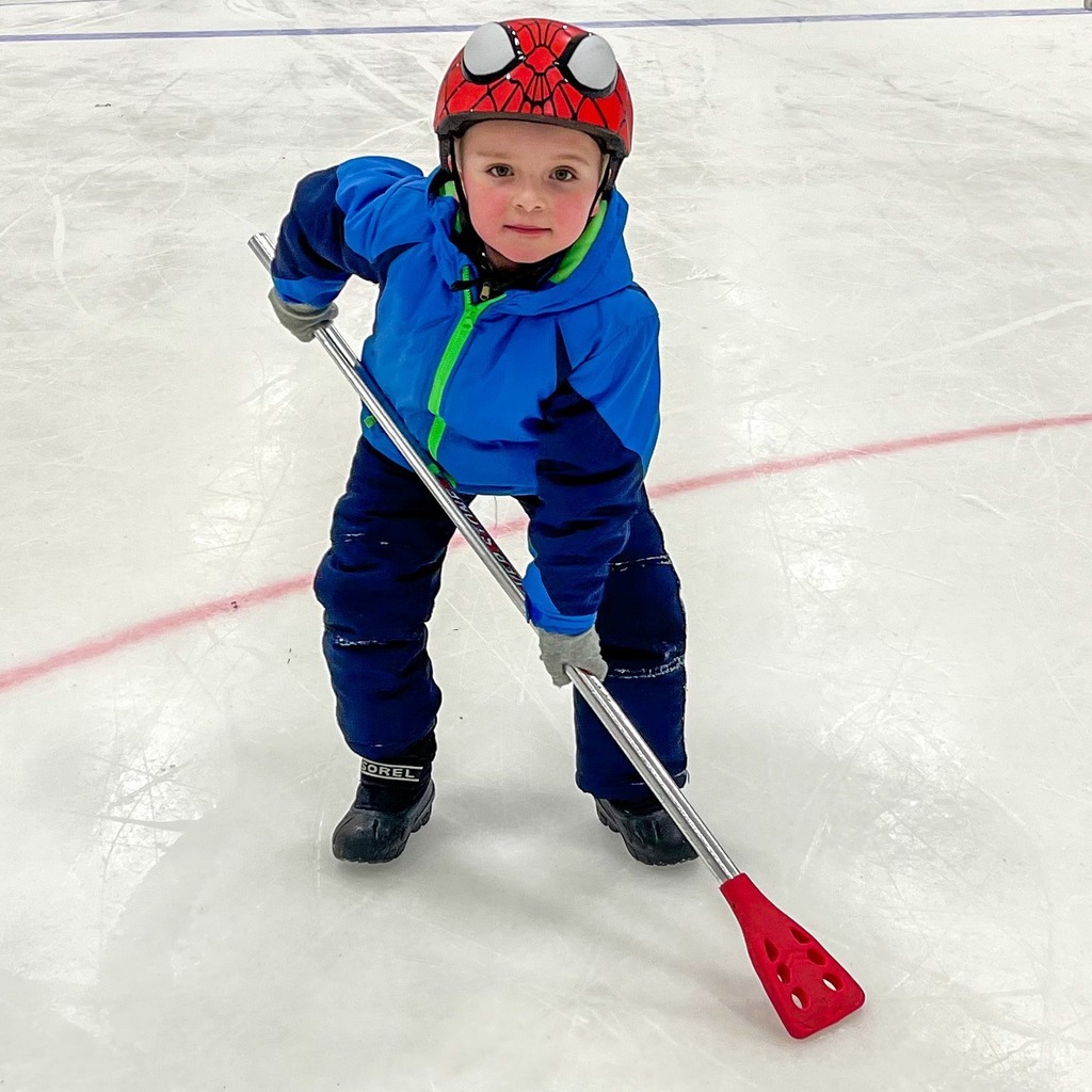 A student in a hockey stance on the ice 
