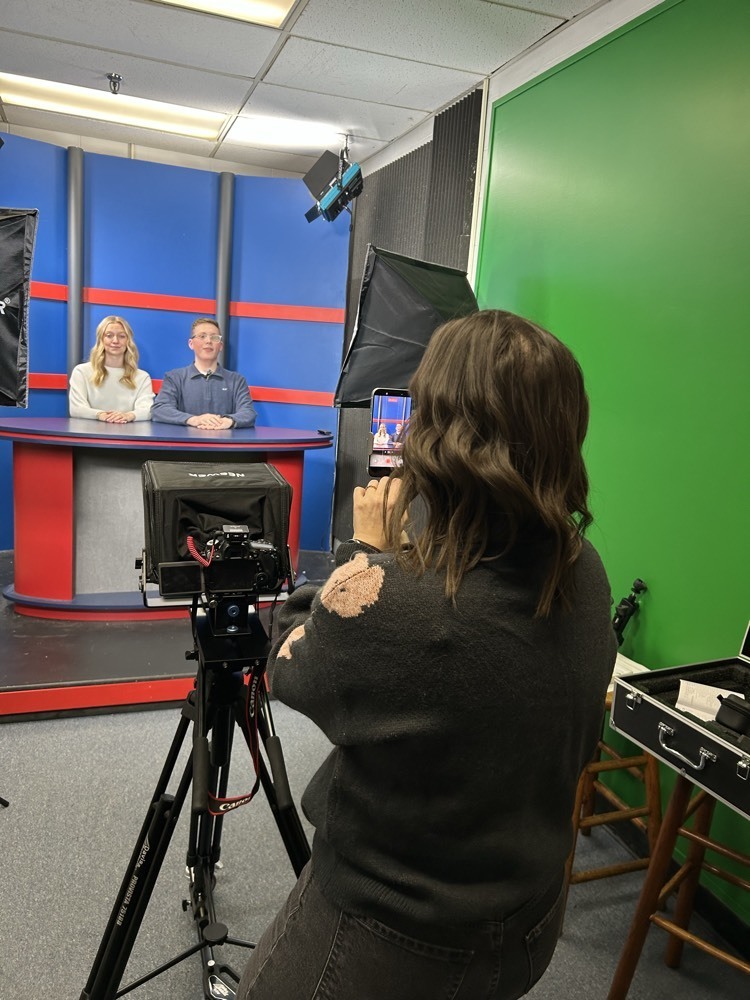 woman films two students speaking 