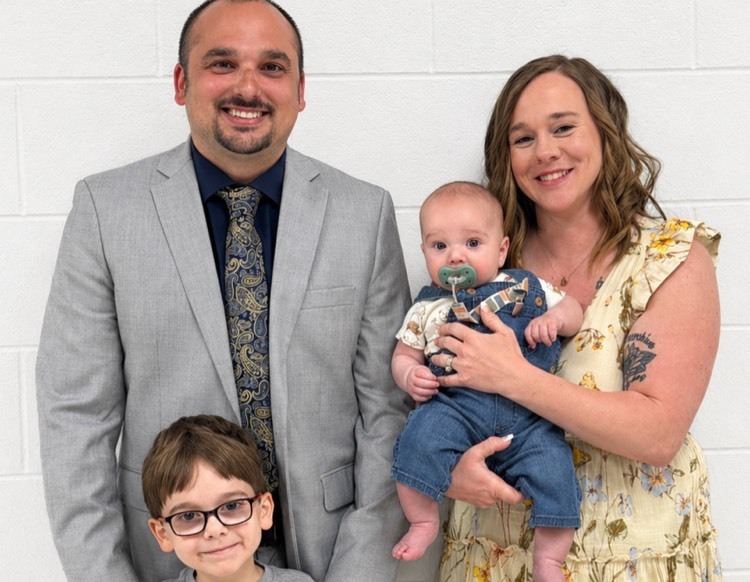 man posing with wife and children