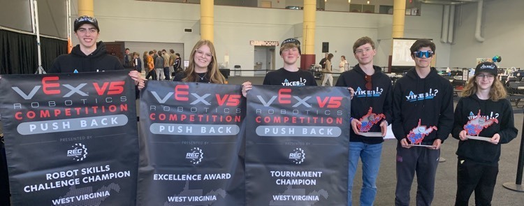 students holding banners stating victories 