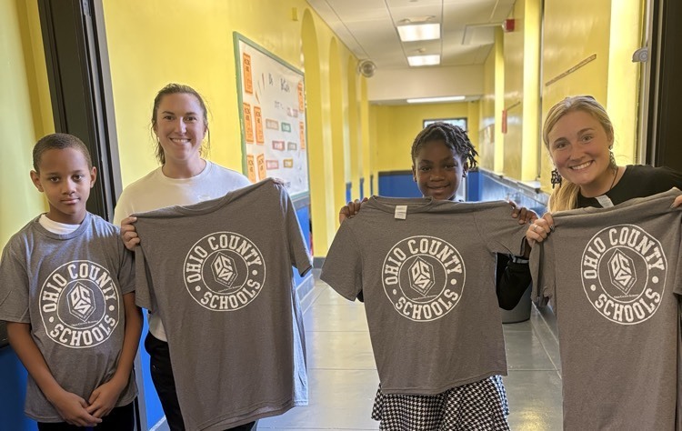 students posing with shirts