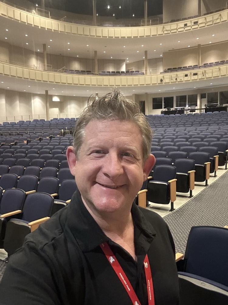 man smiling in large empty theater