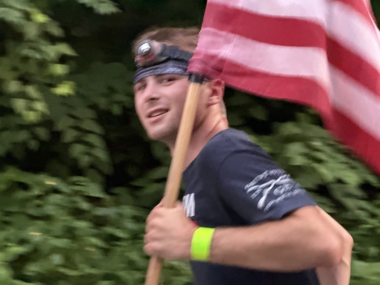 student running carrying flag