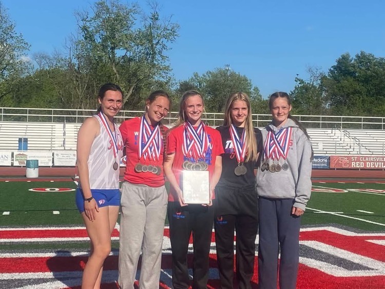 female athletes posing with medals