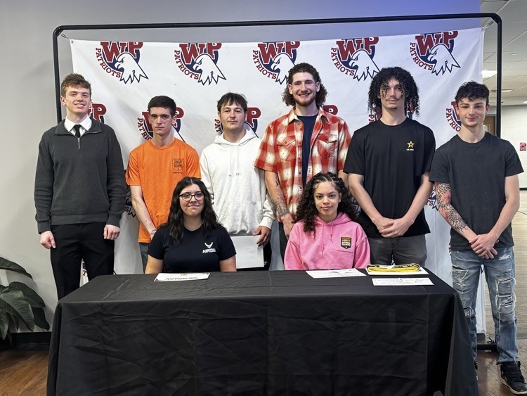 students posing in front of banner 