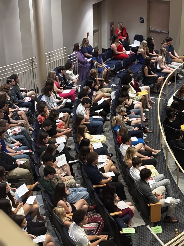 students seated waiting for an announcement