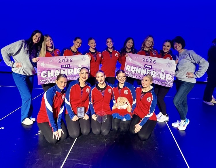 dance team posing with winning banners