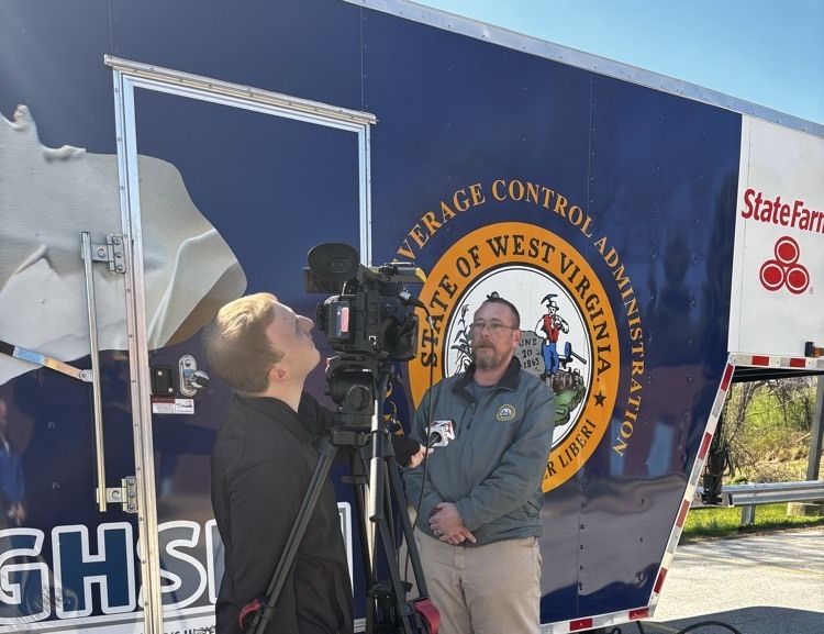 camera man speaking to man in front of trailer