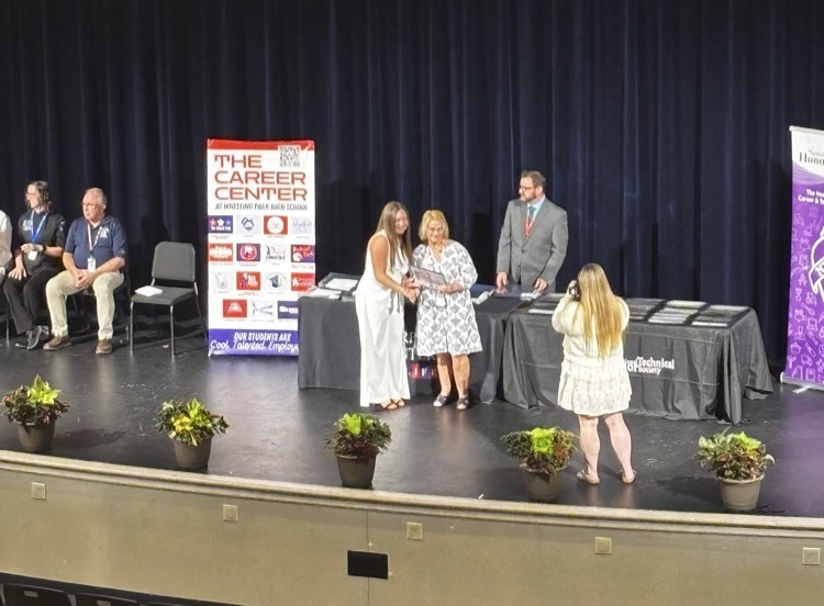 student shaking hands with staff member 