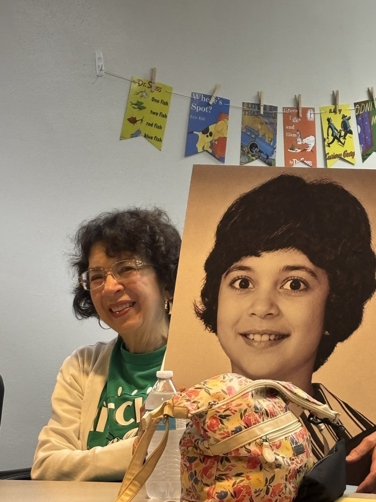 woman posing with a yearbook photo of her younger self