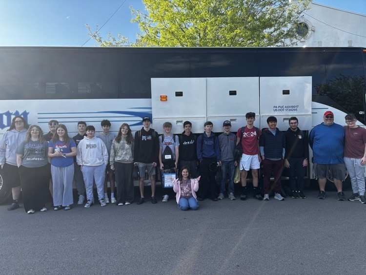 students posing in front of bus