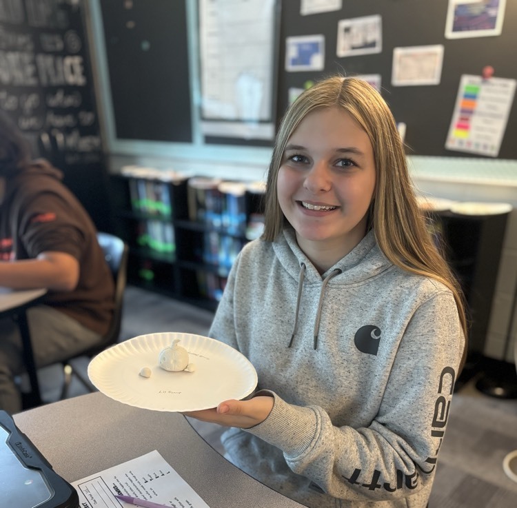 student holding clay