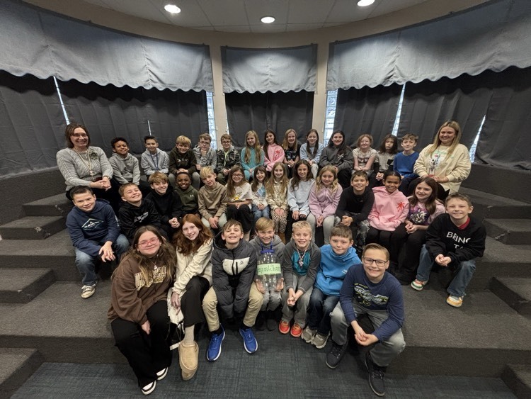 4th grade students seated and posing with teachers
