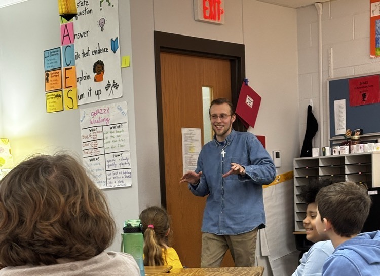 man smiling while teaching children