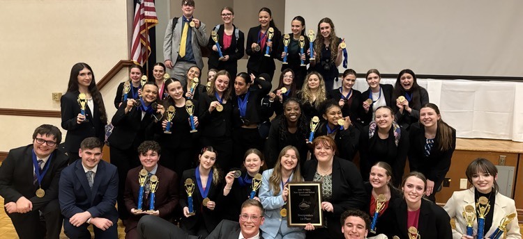 students posing with trophies 