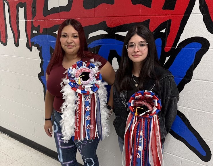 students posing with homecoming ribbons