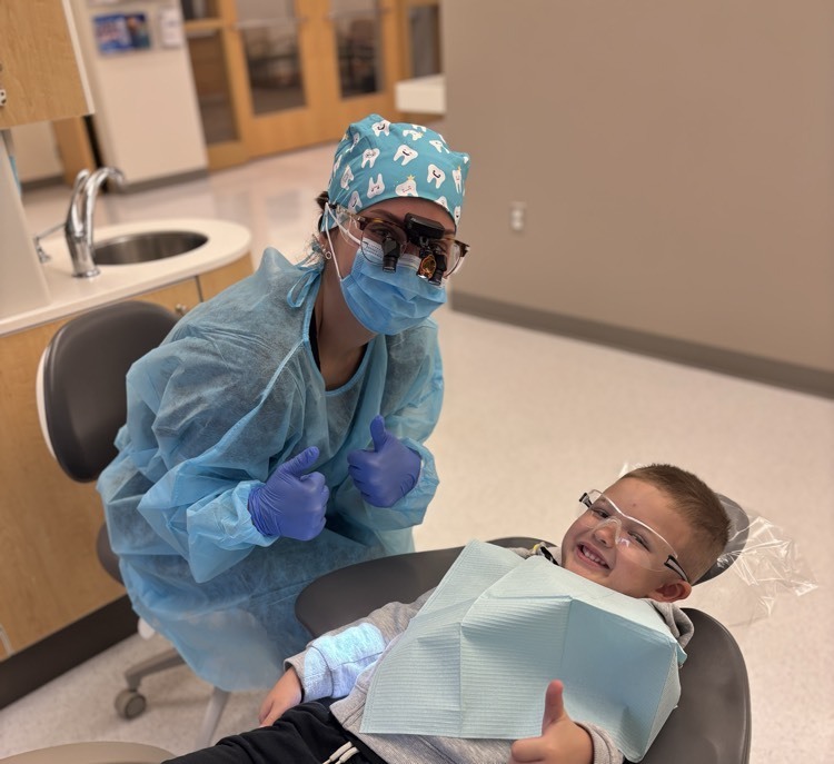 student and dental hygienist smiling
