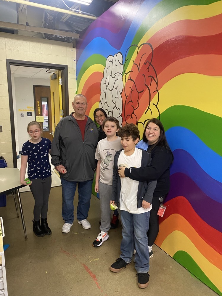 students posing in front of autism wall