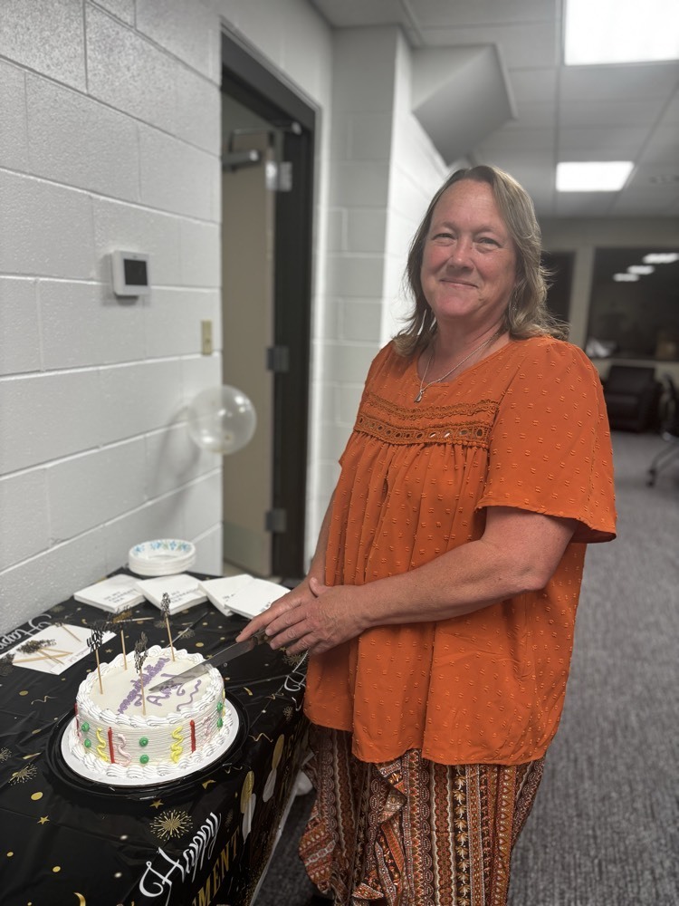 Woman standing by a cake planning to cut it