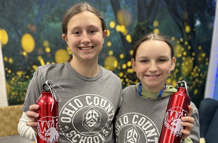 two female students holding water bottles and wearing OCS shirts