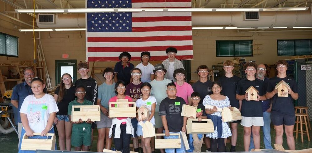 Students from Longwood Elementary, Elliott Point Elementary, and Wright Elementary collaborate in a Build Math program, actively measuring, building, and problem-solving together as they explore fractions, teamwork, and basic construction through hands-on activities.