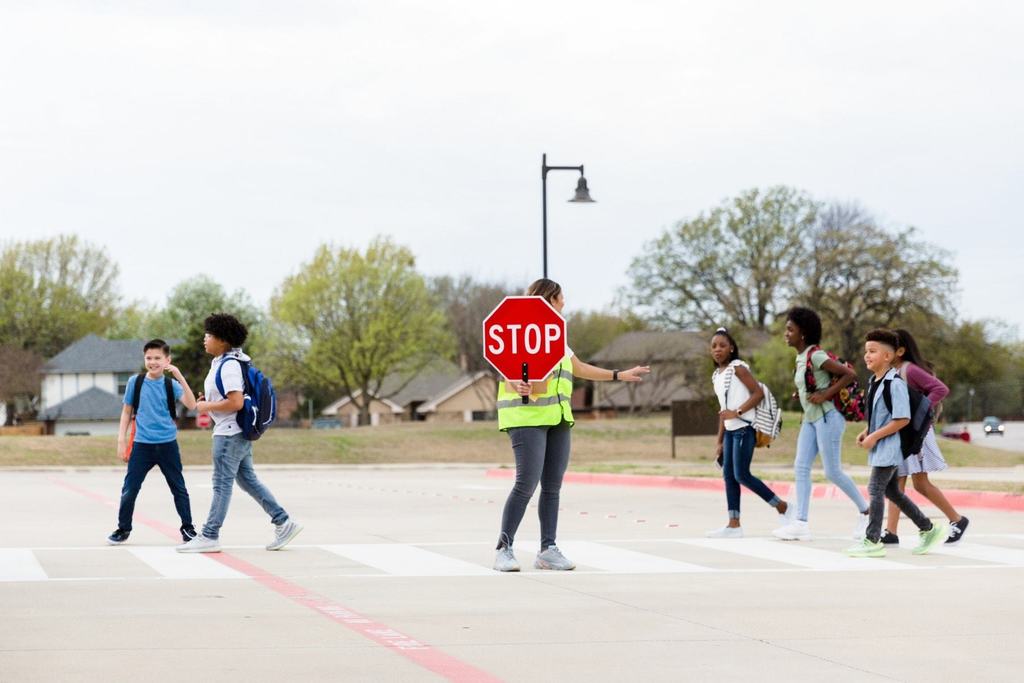 Students crossing street with crossing guard