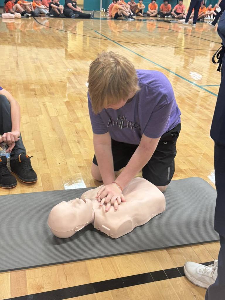Davidson MS student performing CPR on dummy in class