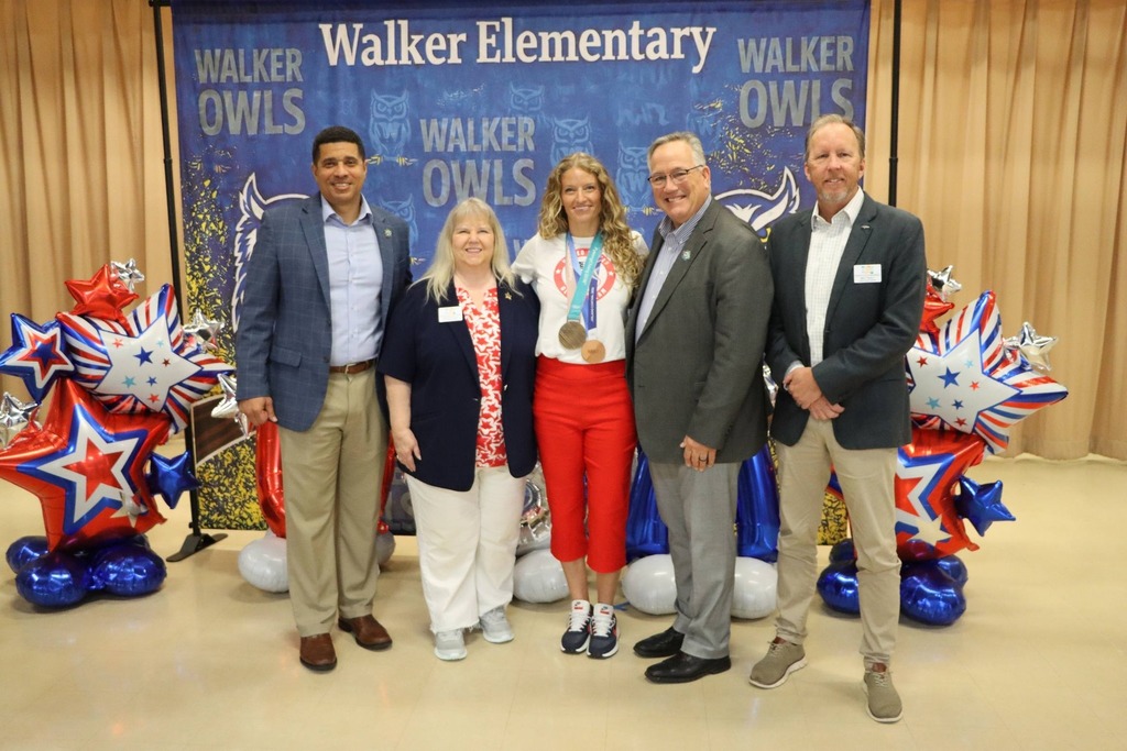 Former Walker Owl and double bronze Olympic speed skater, Mia Manganello, was honored recently at Walker Elementary, and is pictured alongside Superintendent Chambers and School Board members Linda Evanchyk, Brett Hinely, and Tim Bryant.