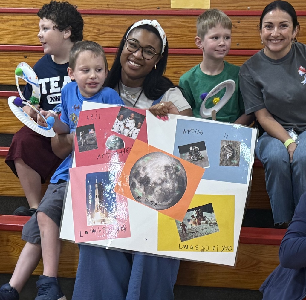 Students and staff display a poster presentation about the Apollo 11 moon landing and space exploration.