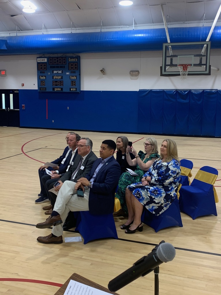 Distinguished guests and school leaders sit in decorated chairs during the Richbourg graduation ceremony in the gymnasium.