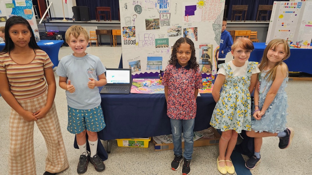  FIRST LEGO League Expo participants in front of their display