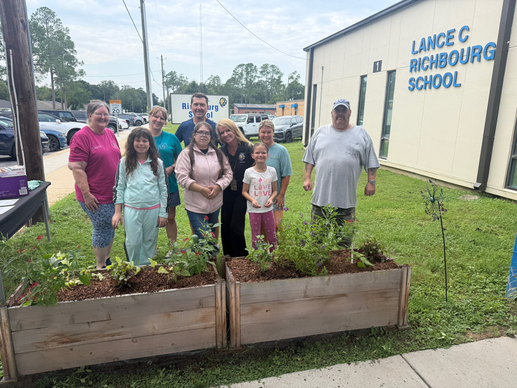 Richbourg students, Ms. Windham the Assistant Principal, and community partners gather behind newly planted raised garden beds outside Lance C. Richbourg School after working together to beautify the campus.