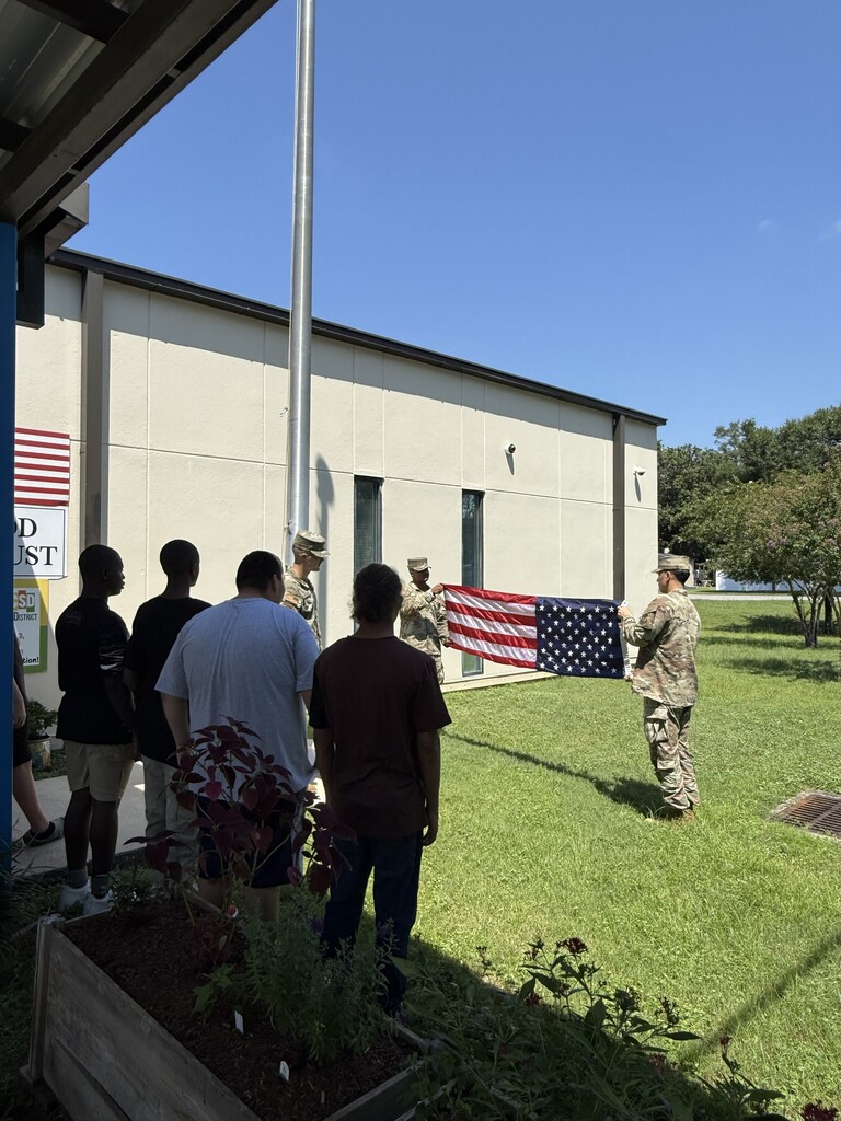 “Members of the Eglin Air Force Base Honor Guard demonstrate the proper procedure for lowering and handling the United States flag at Richbourg School.”
