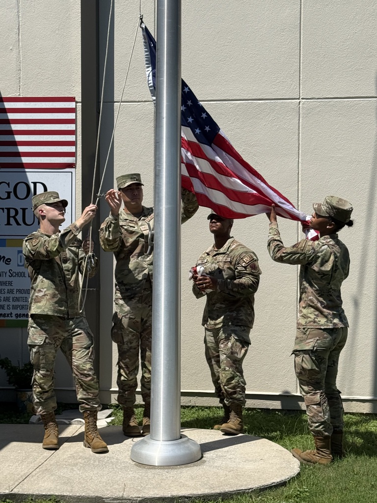 “Members of the Eglin Air Force Base Honor Guard demonstrate the proper procedure for lowering and handling the United States flag at Richbourg School.”