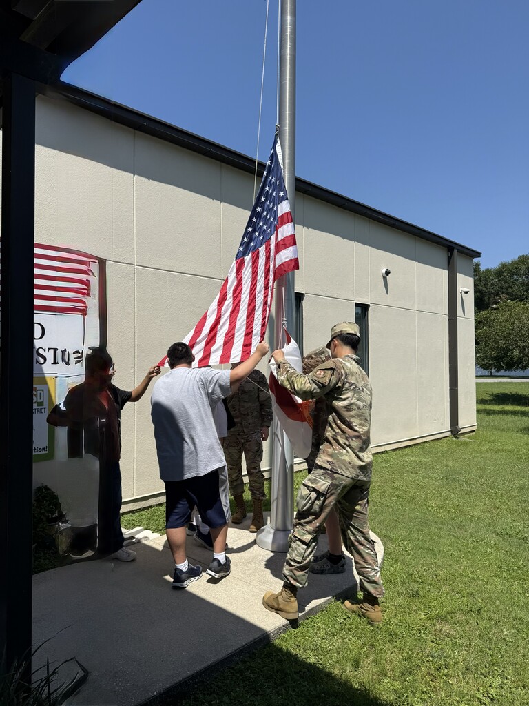 “Richbourg students assist members of the Eglin Air Force Base Honor Guard with the United States and Florida flags during a hands-on flag etiquette demonstration at the school flagpole.”