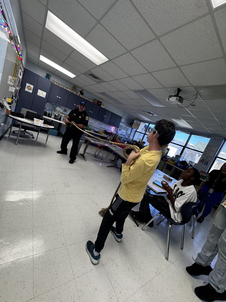 Students learn about push and pull through an interactive rope activity with support from an educator and the school resource officer during a hands-on science lesson.