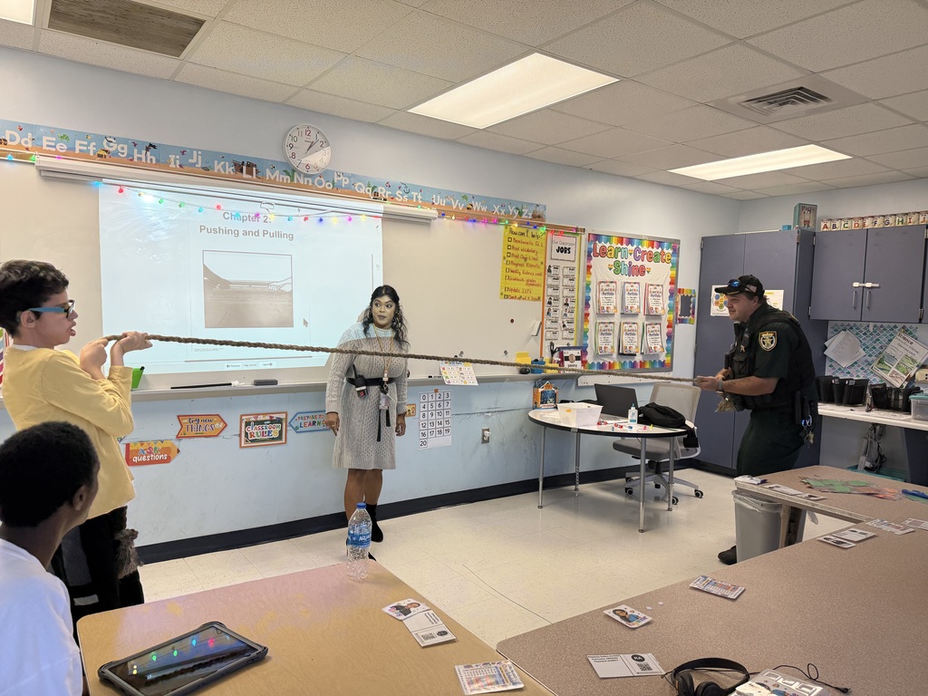 Students learn about push and pull through an interactive rope activity with support from an educator and the school resource officer during a hands-on science lesson.