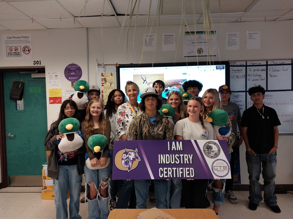 group of science students holding certified sign in classroom