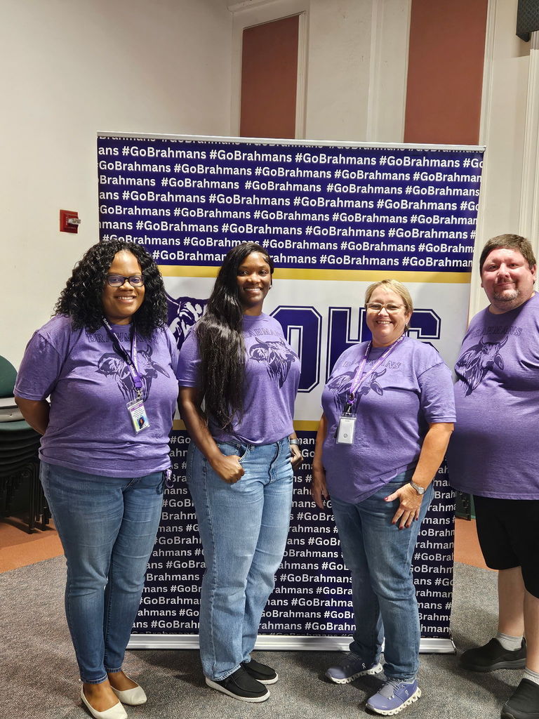 four admin wearing the same purple brahman shirt Infront of brahman backdrop