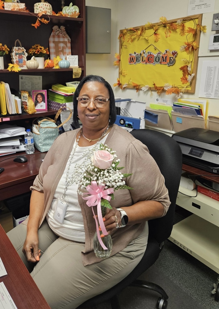 school staff member holding vase with pink flower