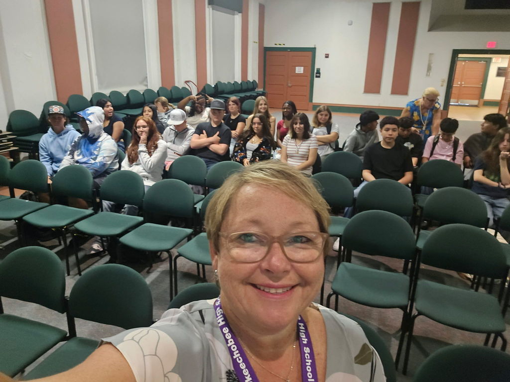 principal taking selfie with students in auditorium for town hall meeting