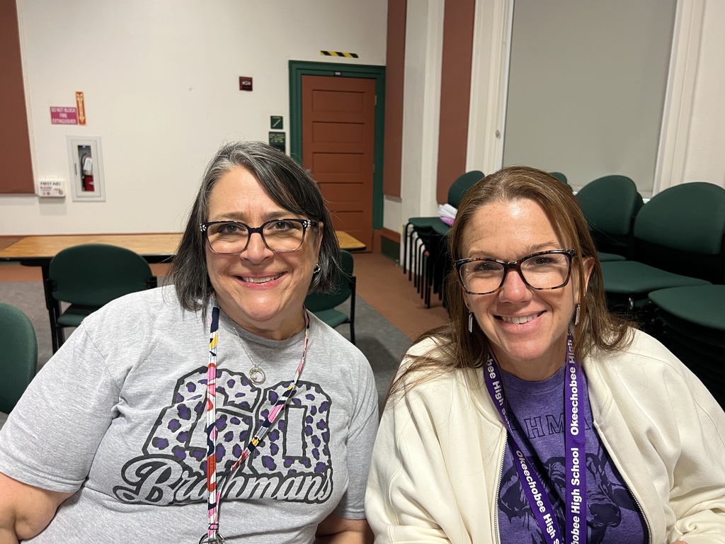 two teachers smiling in school auditorium