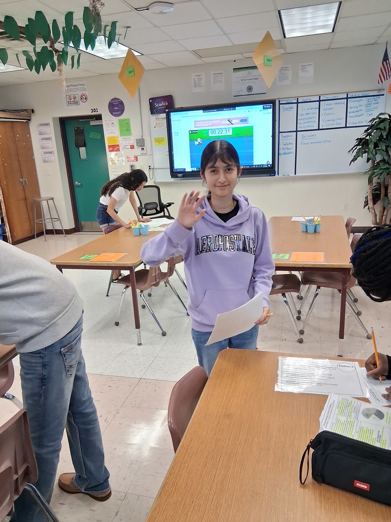 student waving and working on scavenger hunt for science syllabus