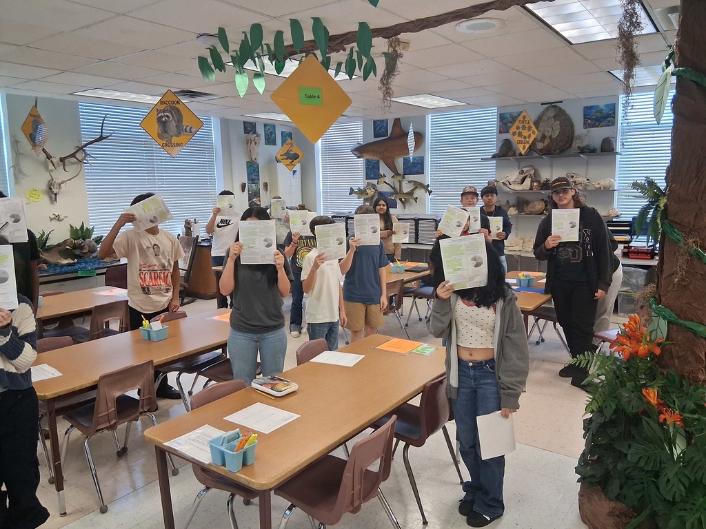 students covering face with syllabus