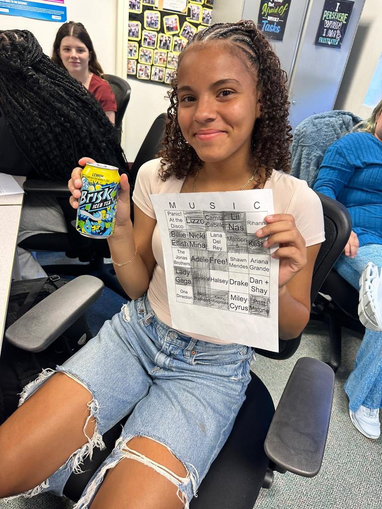 student showing off paper and tea in digital tech