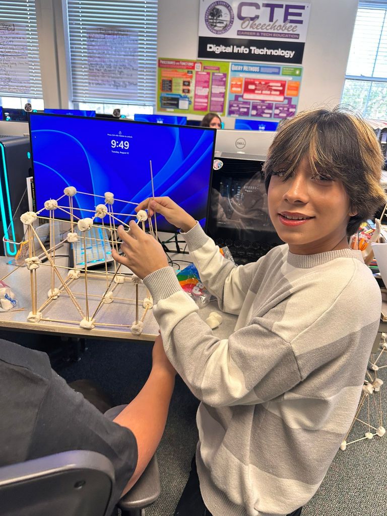 student doing marshmallow project by computer in digital tech class