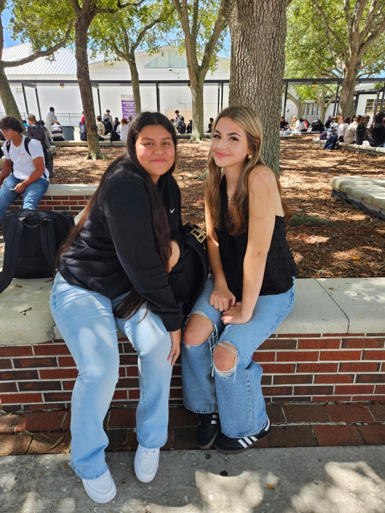 two girls smiling in school courtyard