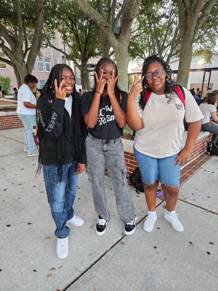 three students in the courtyard of school