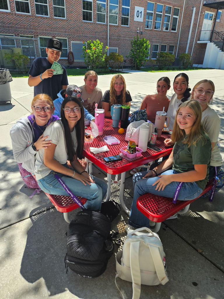 ten students sitting in table at courtyard during lunch
